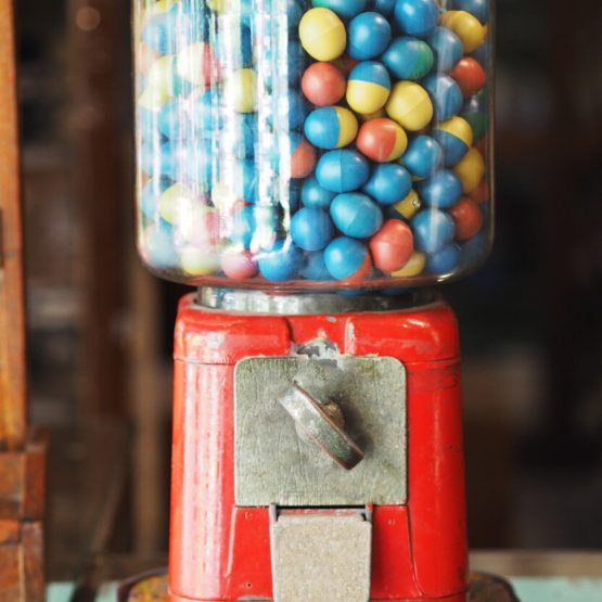 gamble eggs in vintage gumball machine on glass counter at grocery store